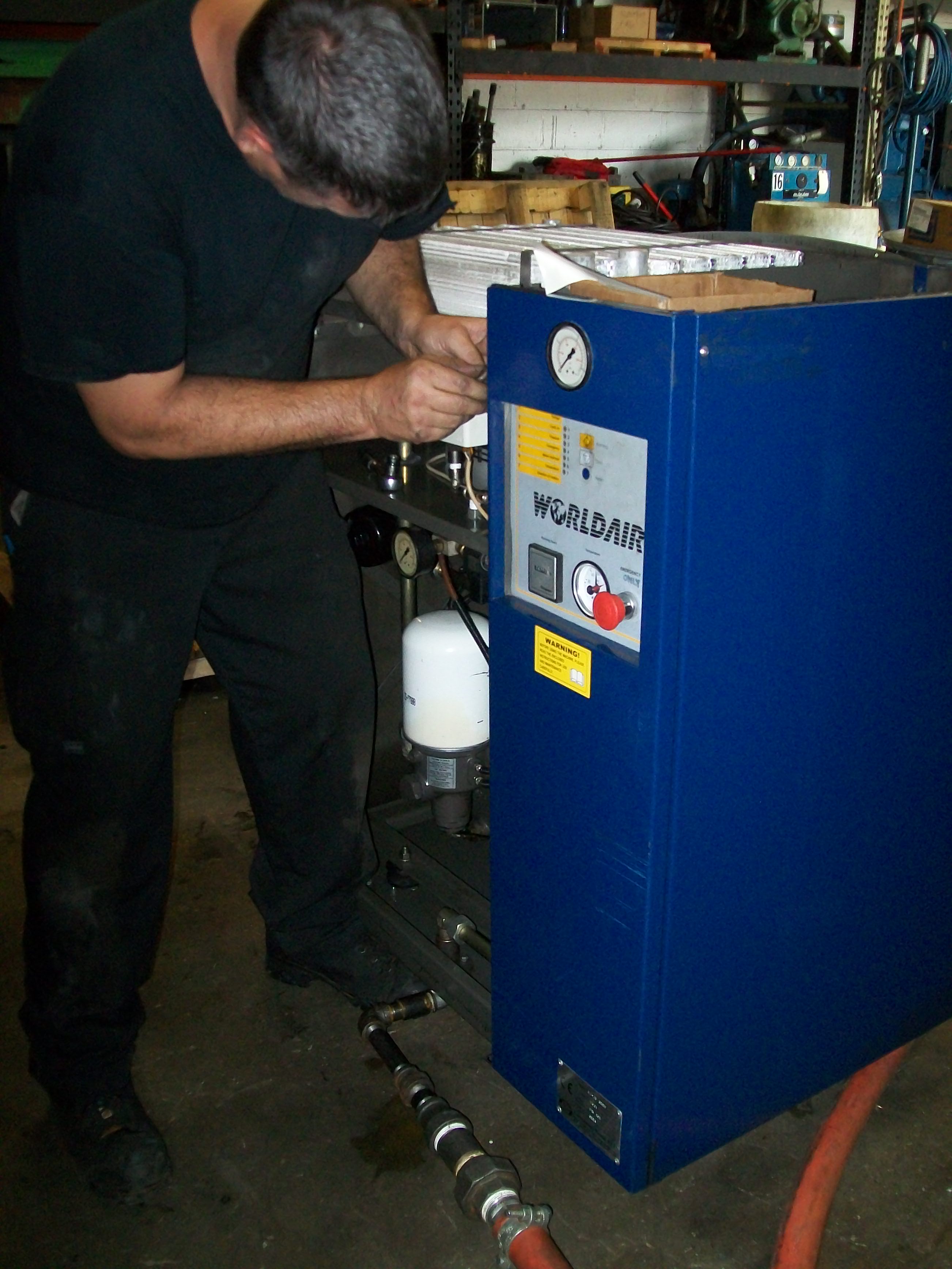 aggressive air compressor co employee performing an air compressor preventative maintenance